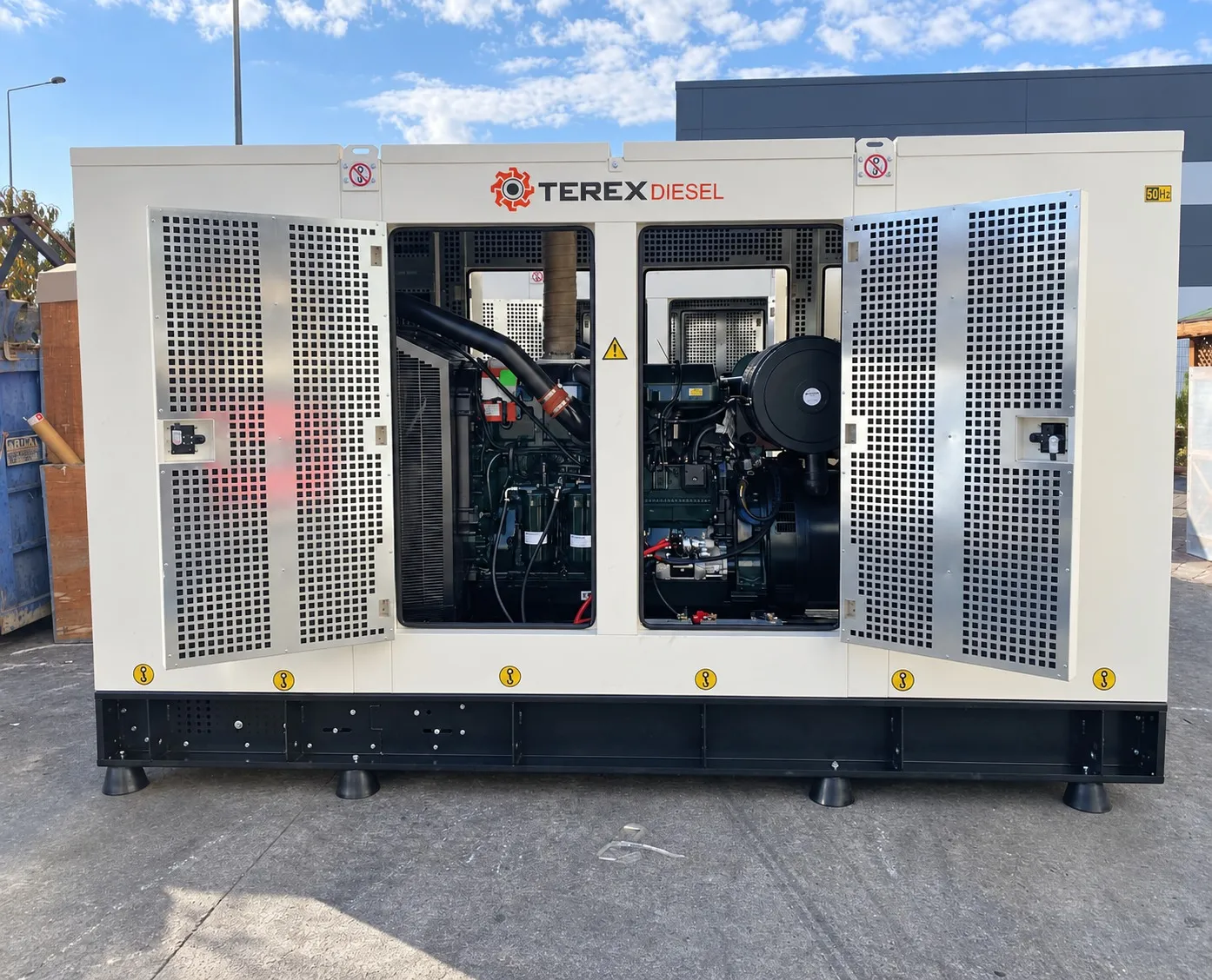 Dış mekânda servis kapıları açık Terex Diesel kabinli jeneratör; motor bölmesi görünüyor.